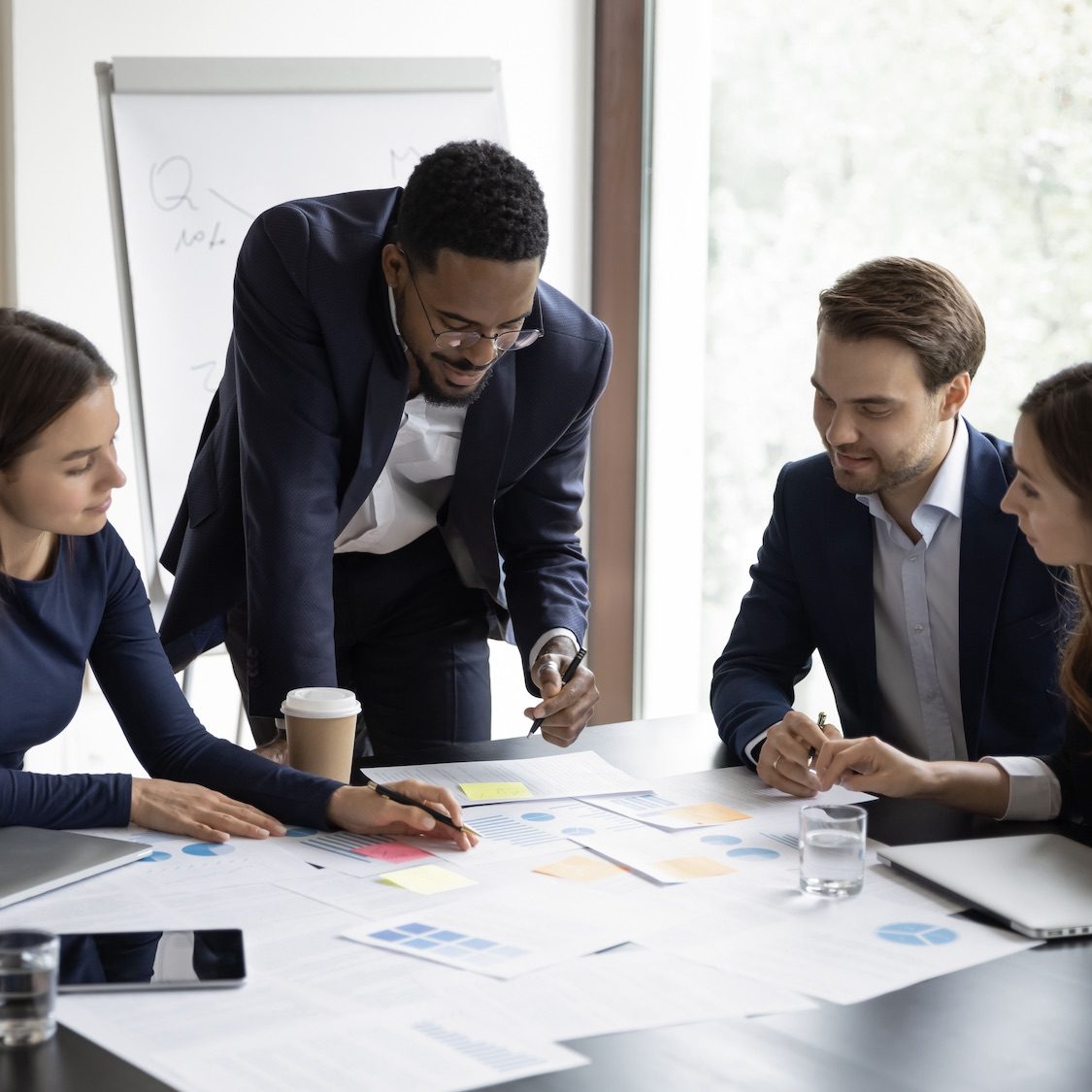 Multiethnic colleagues brainstorm at team meeting in office